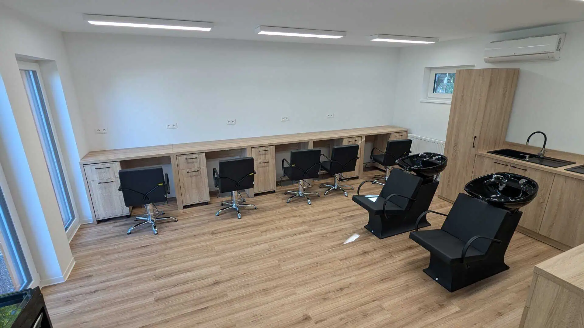 Moderný interiér modulárneho kaderníckeho salónu v Trnave s kaderníckymi kreslami a umývacími boxmi